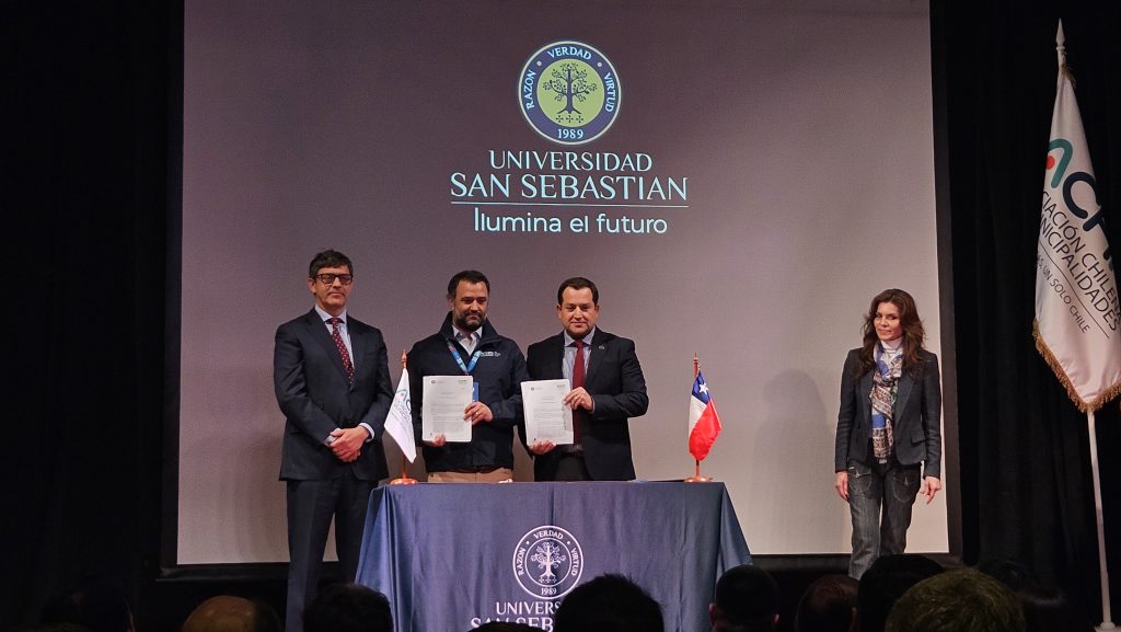 se muestra a los representantes de la Universidad San Sebastián y la Asociación Chilena de Municipalidades firmando el acuerdo de colaboración mutua en políticas deportivas